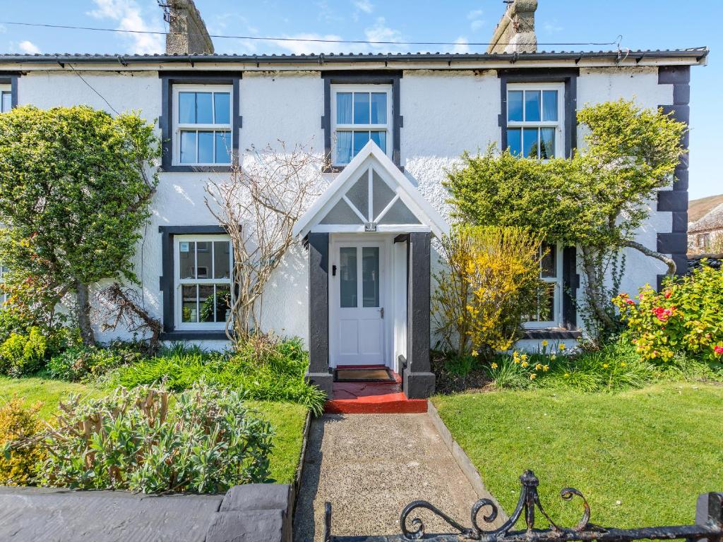 a white house with a white door and windows at Court End Cottage in Silecroft