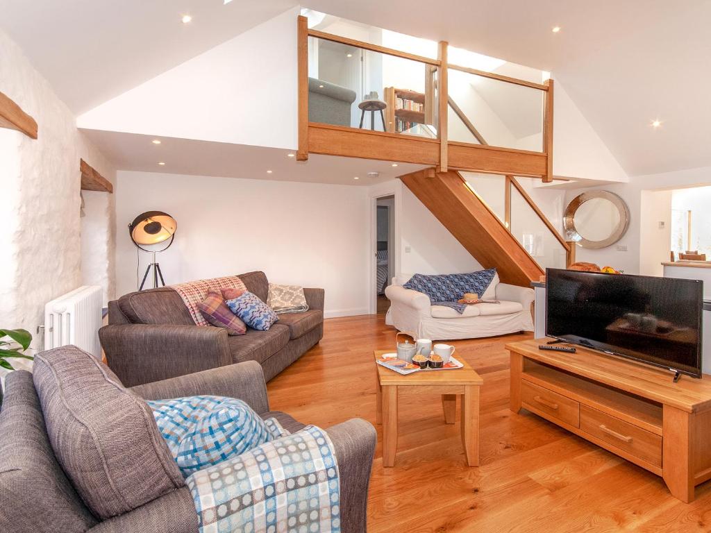 un soggiorno con due divani e una TV a schermo piatto di The Loft - Cottage a Letterston