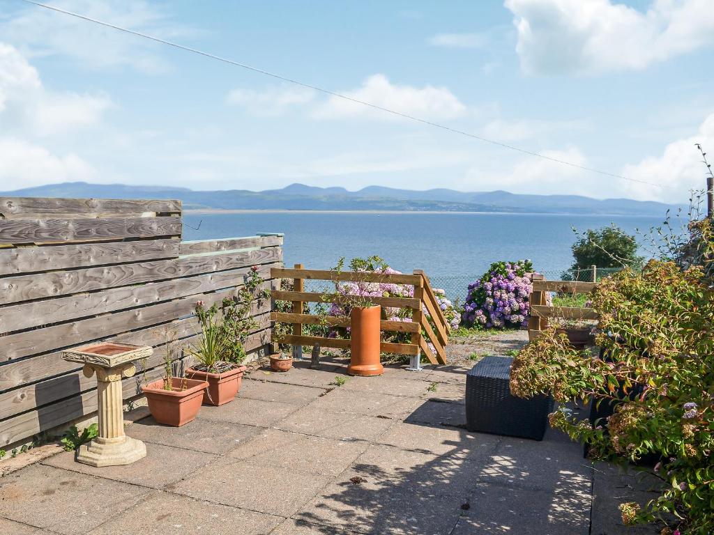 a garden with a fence and a view of the water at Morlais in Criccieth