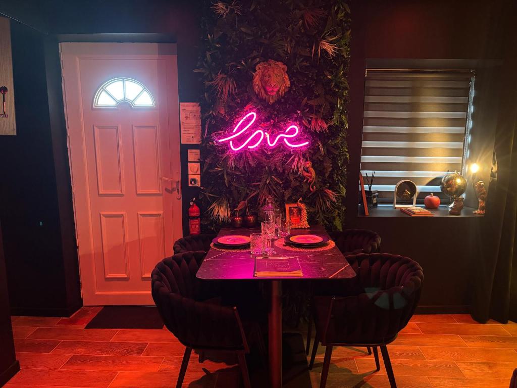 a table with a neon love sign on the door at La Sainteny Touch in Sainteny