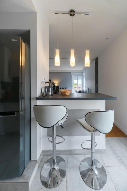 a kitchen with two bar stools and a counter at Le Sainte Barbe - Hyper Centre - Parc des sources in Vichy