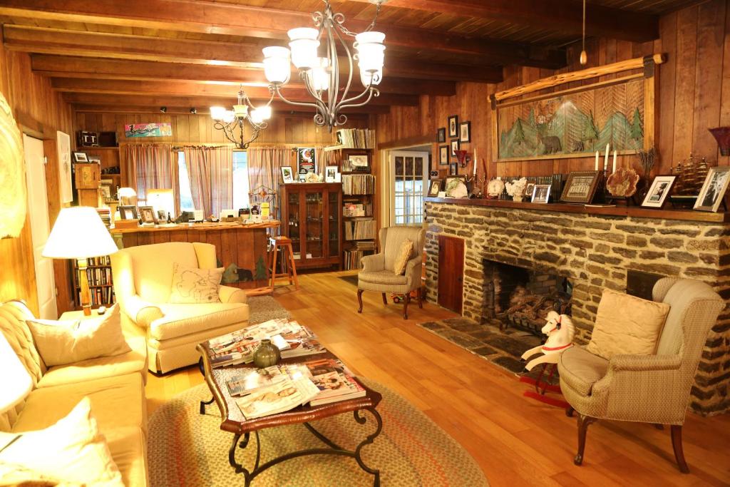 a living room with a stone fireplace and chairs at Grandview Lodge in Waynesville