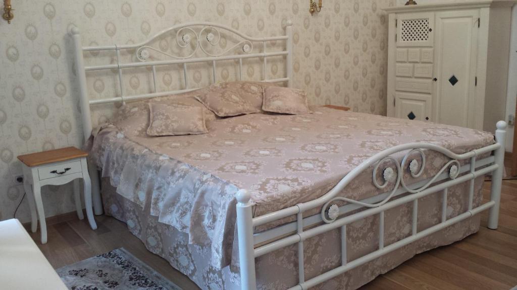- une chambre dotée d'un grand lit avec un cadre blanc dans l'établissement Elegance Residence, à Timişoara