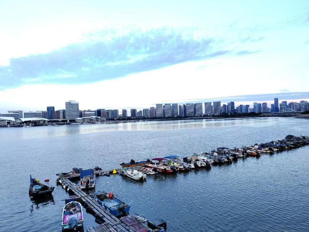 a group of boats parked at a dock in the water at 南屿轻奢影院酒店 近厦门高崎国际机场和地铁站 近五缘湾景区 近湾悦城商圈 in Xiamen