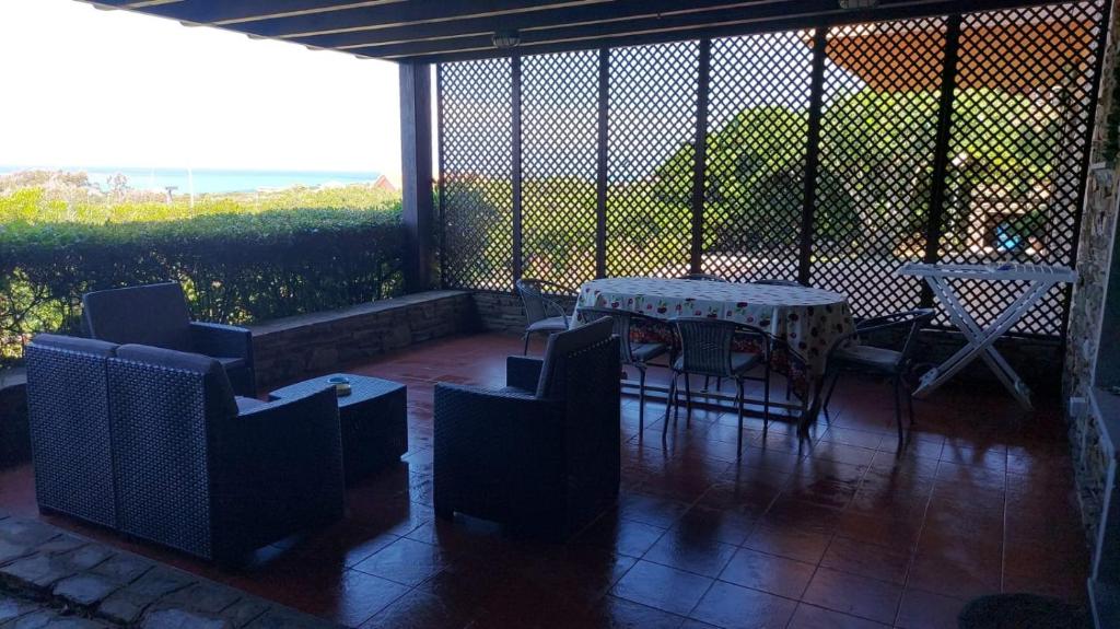 a patio with a table and chairs and a view of a field at Case Verdemare Stintino in Stintino