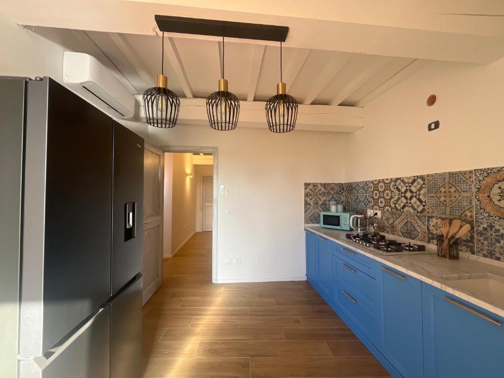 a kitchen with blue cabinets and black appliances at Prima Luce in San Donato in Poggio