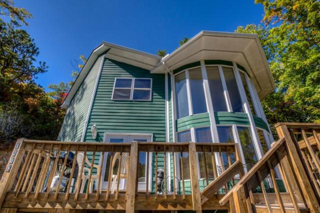 een groot groen huis met een groot terras bij 21A Edelweiss in Chalet Village