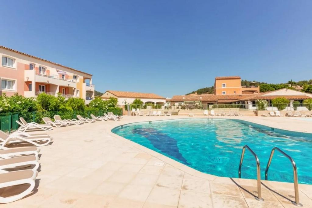 a swimming pool with lounge chairs next to a building at Apartment with view in Roquebrune-sur-Argens in Roquebrune-sur-Argens