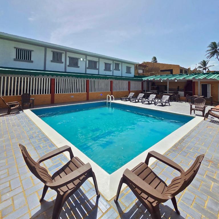 ein Swimmingpool mit zwei Stühlen und ein Swimmingpool in der Unterkunft Tucacas, Frente al Mar, Vista a la Piscina y Playa Privada in Boca de Aroa