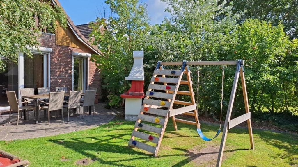 a playground with a ladder in a yard at Großes Ferienhaus Dagebüll mit Kamin in Dagebüll