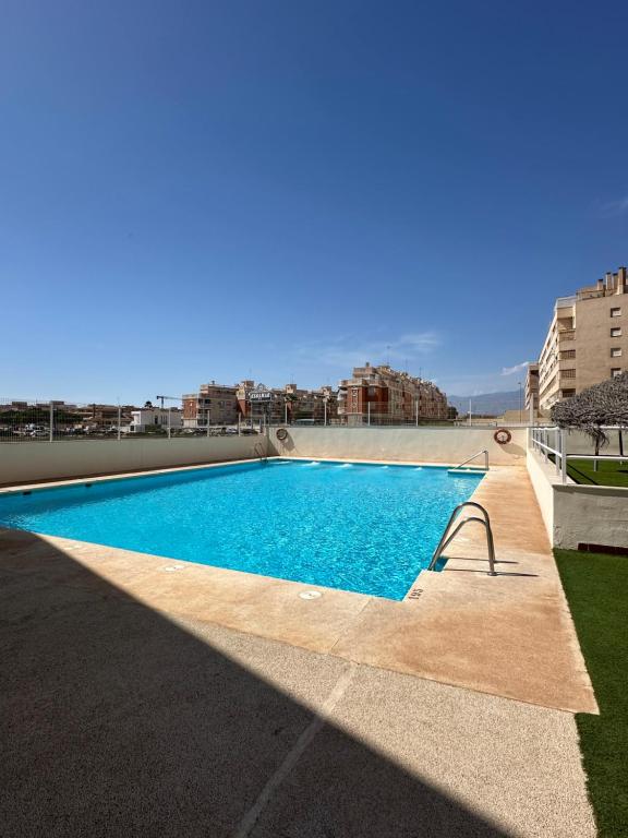 a swimming pool on the roof of a building at Apartamentos JM - Sea & Sun in Roquetas de Mar