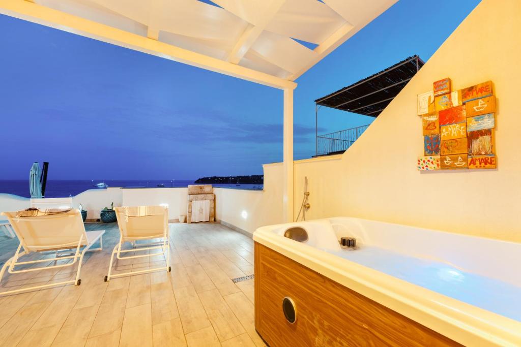 a large bathroom with a tub and two chairs at Stella di Mare in Procida