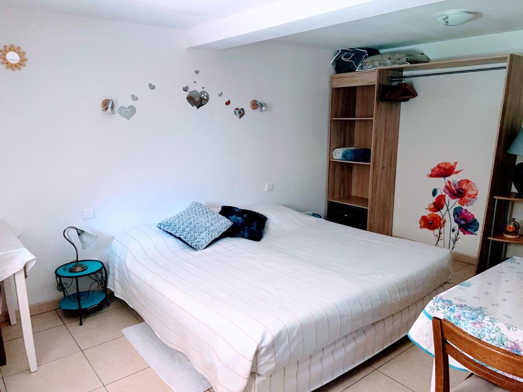 a bedroom with a white bed in a room at chambre et salle de bain privé s'ouvrant sur terrasse, jardin et cuisine d'été in Quillan