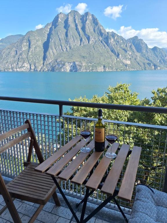 a bottle of wine sitting on a table with wine glasses at Appartamento sul Lago con Terrazza Panoramica in Riva di Solto