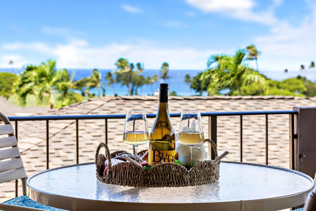a table with a bottle of wine and glasses on a beach at Maui Eldorado Condo K217 in Kaanapali