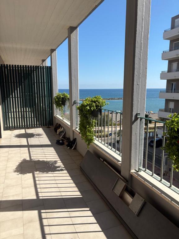 a balcony with two cats looking out at the ocean at Bari Double Sea View in Bari