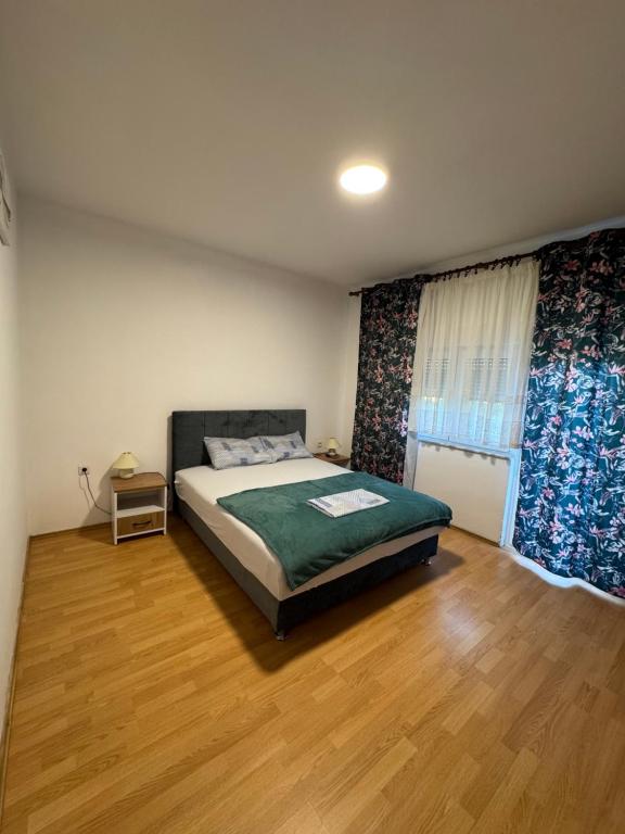 a bedroom with a bed and a wooden floor at Kuća za odmor Nikola Medjugorje in Čitluk