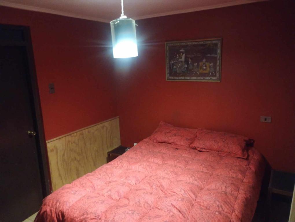 a bedroom with a bed in a red wall at Casa relax in Coquimbo