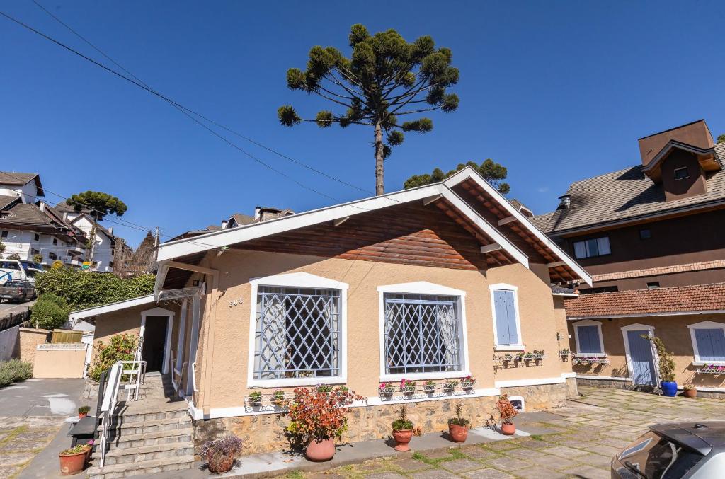 a small house with a tree in the background at Pousada Vila Tio Lé in Campos do Jordão