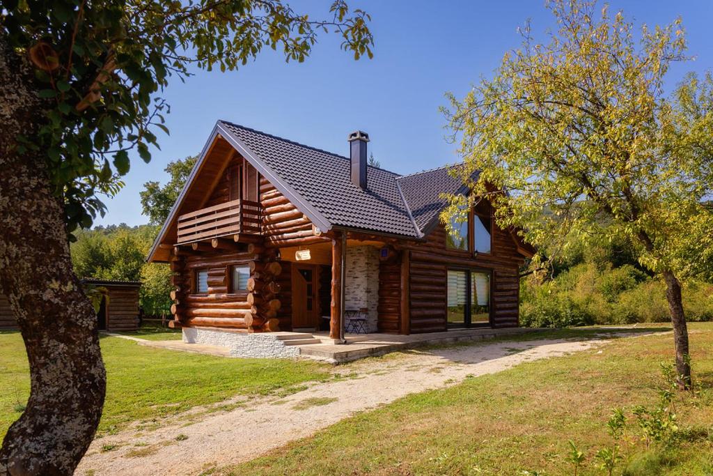 a log cabin with a tree at Vacation home Elizabeta in Slunj