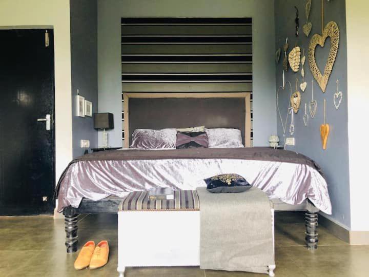 a bedroom with a large bed and some shoes at Irishhome stay in Hosūr