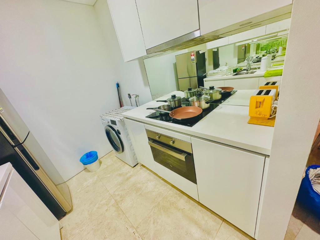 a kitchen with white counters and a stove top oven at vortex KLCC YOUR HOME in Kuala Lumpur
