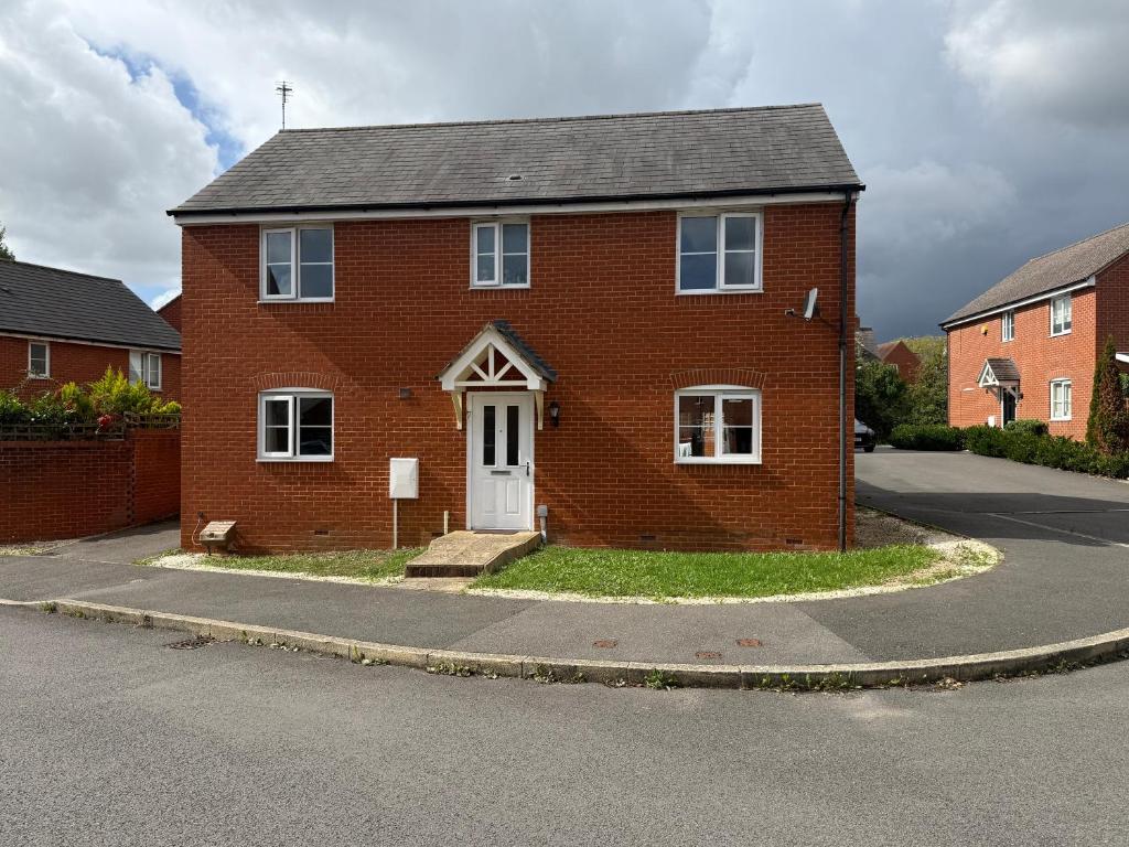 una casa de ladrillo rojo con una puerta blanca en una calle en Aylesbury, en Buckinghamshire