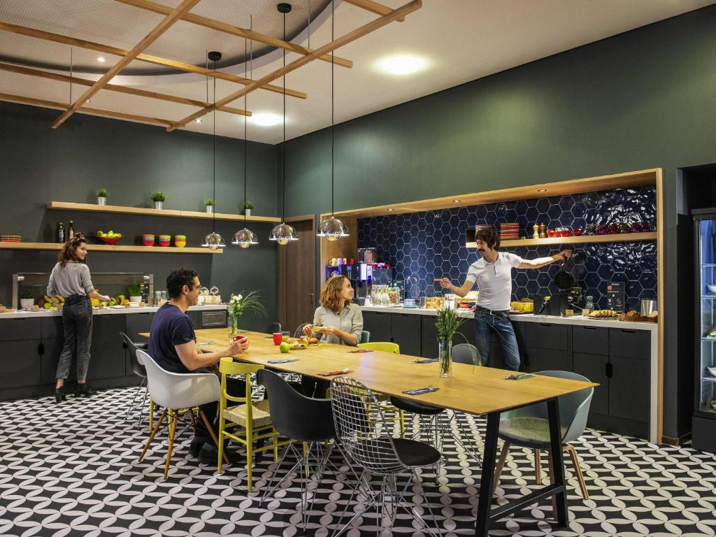 a group of people sitting around a table in a kitchen at Aparthotel Adagio Berlin Kurfürstendamm in Berlin