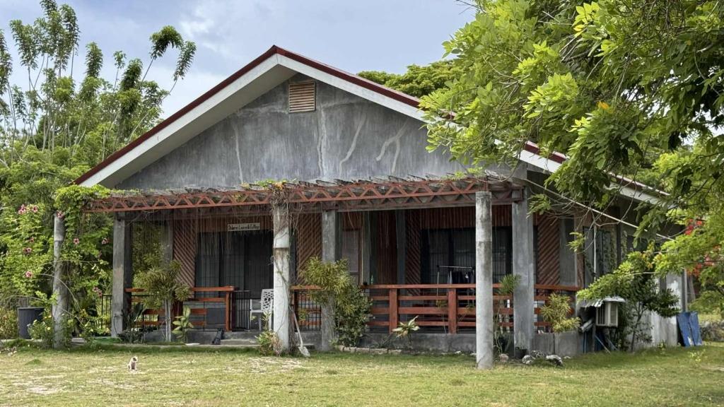 une petite maison avec une véranda et des arbres dans l'établissement Santander Beach Cottage, à Santander