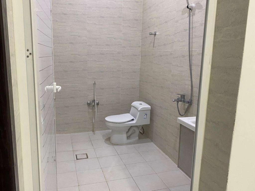 a bathroom with a toilet and a glass shower at شقق الوسام الفندقية in Hafr Al Baten