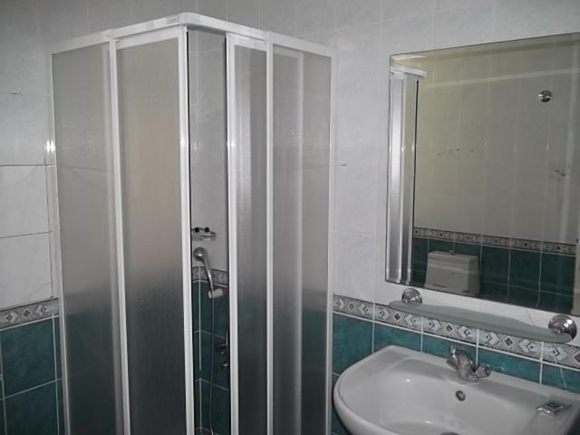 a bathroom with a sink and a shower and a mirror at Antik Ridvan Hotel in Çeşme