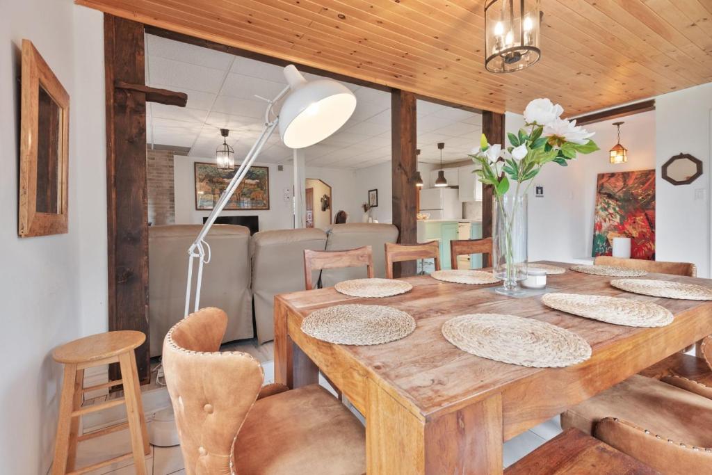 a dining room with a wooden table and chairs at L'Évasion - 4CH - Piscine - Spa et Salle de jeux in Saint Zenon