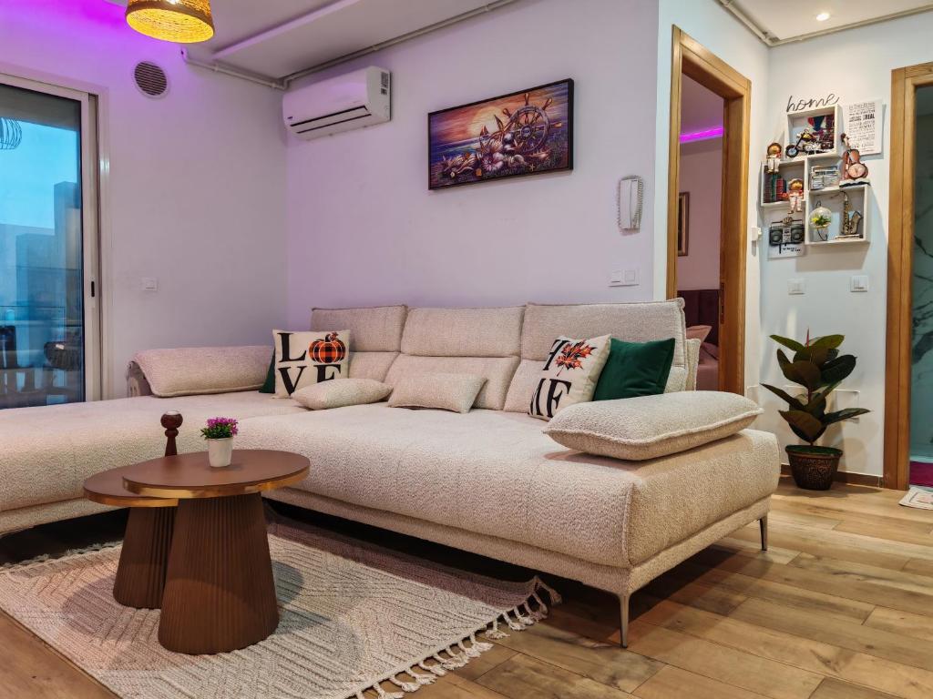una sala de estar con un sofá y una mesa en Hammamet appart with pool, en Nabeul