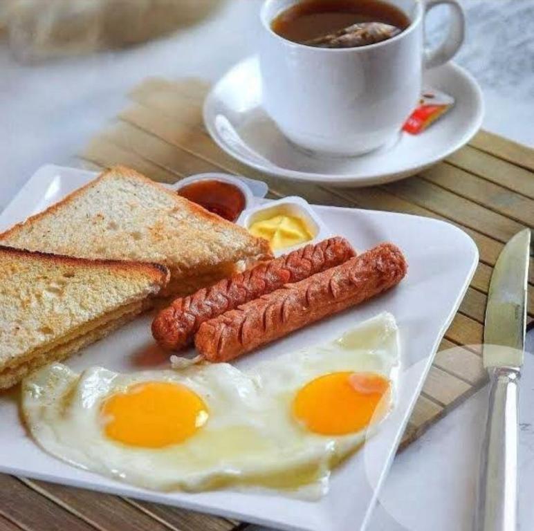 a plate of eggs and toast and a cup of coffee at Peridot Open Sky T Garden in Bandarawela