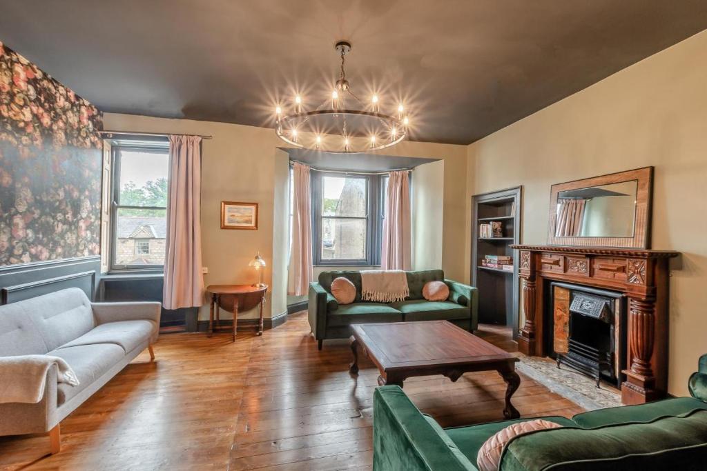 een woonkamer met een bank en een open haard bij Bondgate House in Alnwick