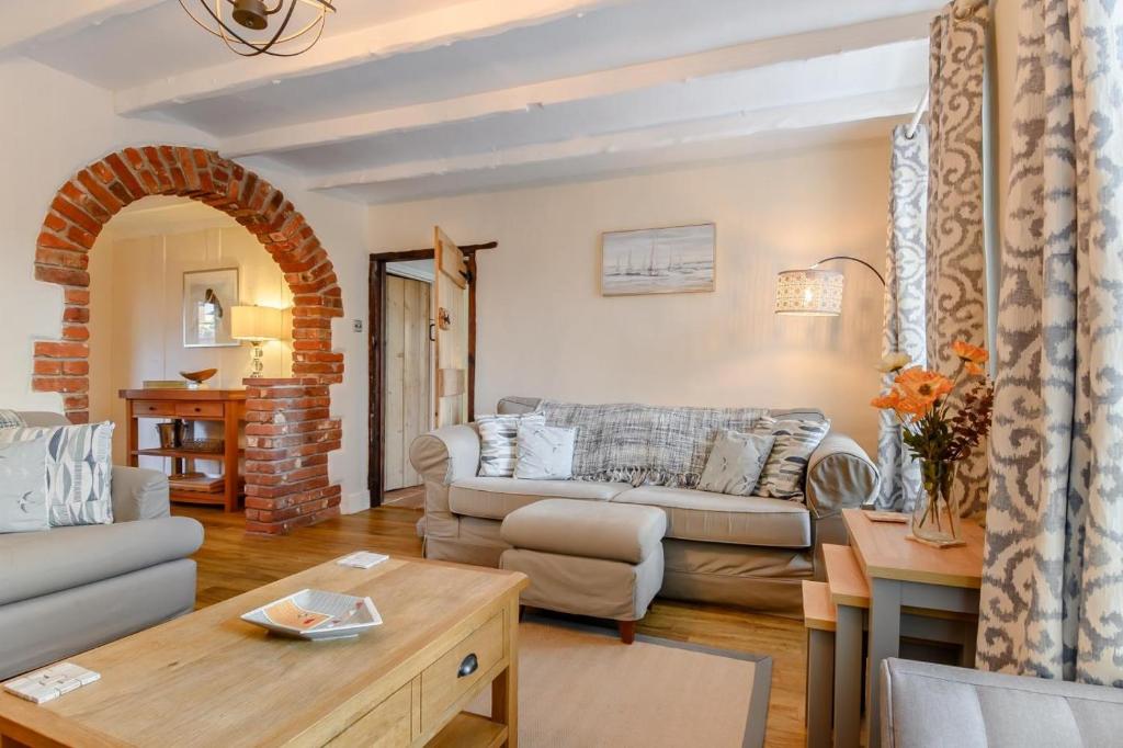 a living room with a couch and a table at Mill Pond Cottage in Sheringham