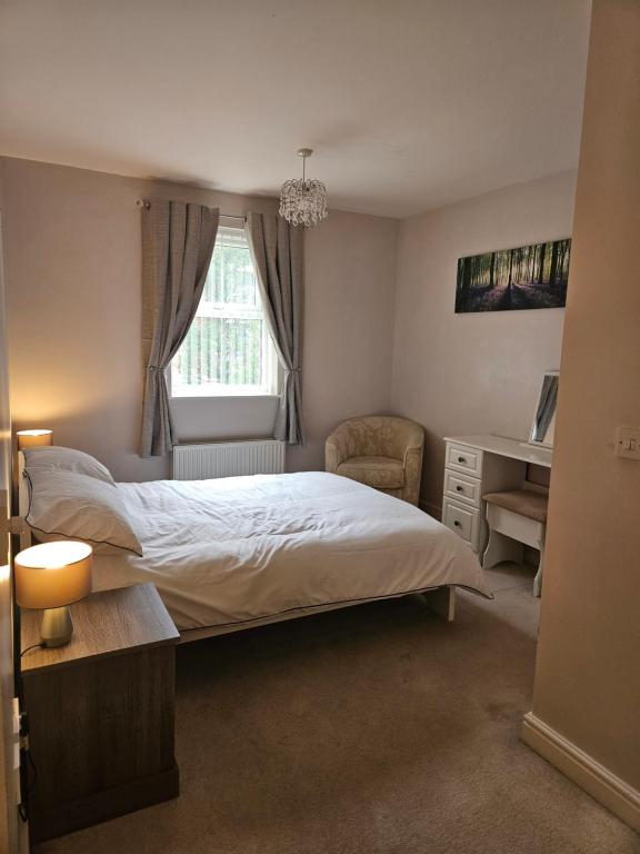 une chambre avec un lit, une chaise et une fenêtre dans l'établissement Bargh Apartment - 2 bed 2 bath, modern comfort, à Balderton
