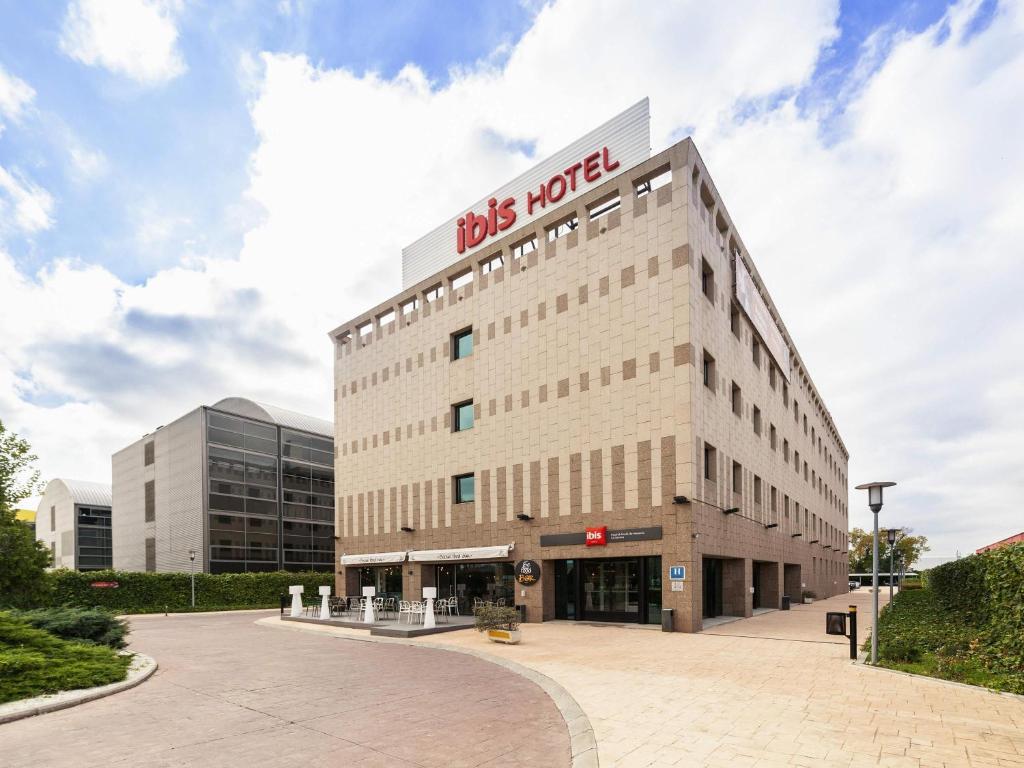 a building with a sign on the top of it at Ibis Alcala de Henares La Garena in Alcalá de Henares