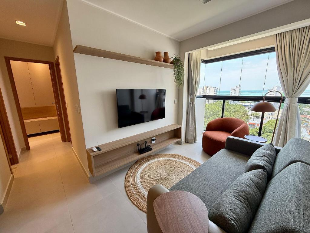 a living room with a couch and a television at Studio Design 3 Apt 801 -Mandi Hospitalidade in Maceió