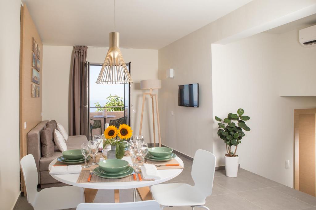 a white dining room with a table and chairs at Sundance Apartments & Suites in Hersonissos