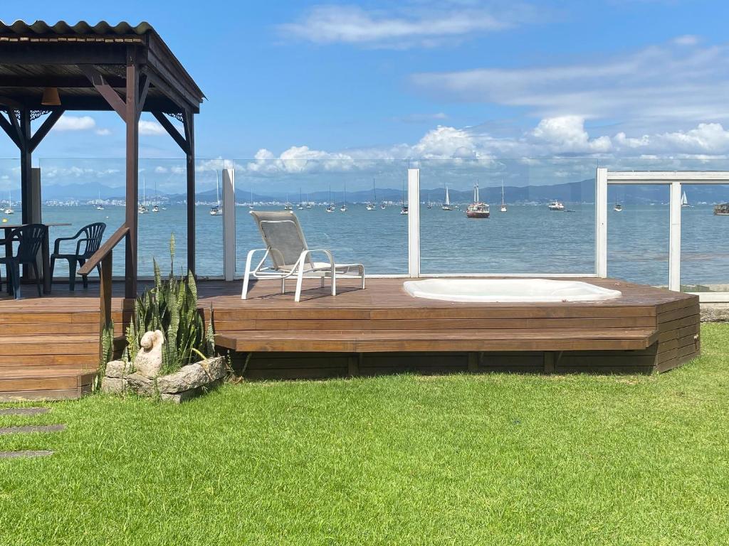 un ponte con una sedia appoggiata sull'acqua di FLORIPA PÉ na AREIA a Florianópolis