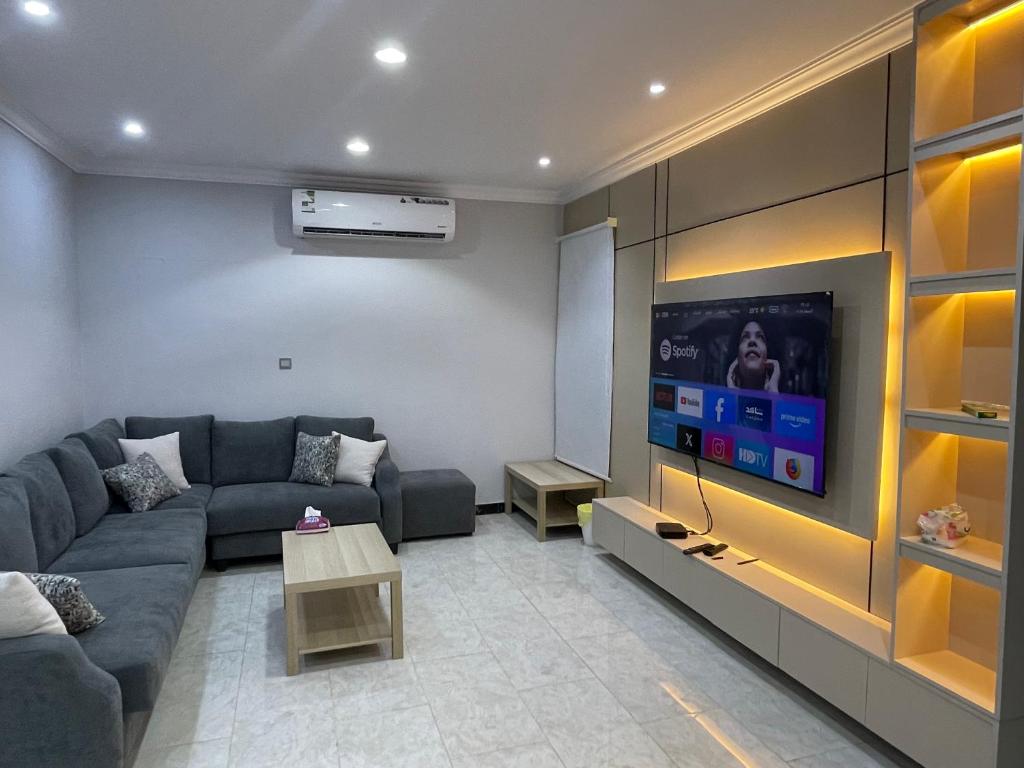 a living room with a couch and a flat screen tv at شقة ذات موقع رائع in An Nikāshah