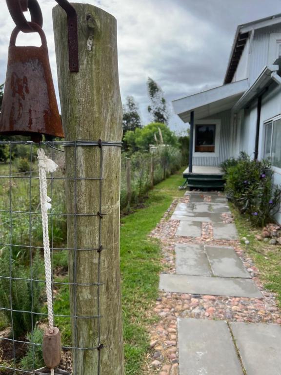 a wooden fence with a rusted bell on it at El ático in Barra de Portezuelo