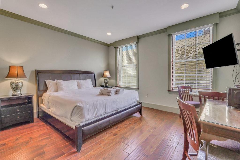 a bedroom with a bed and a desk and a television at McDonough's Inn Unit 1 by Lucky Savannah in Savannah