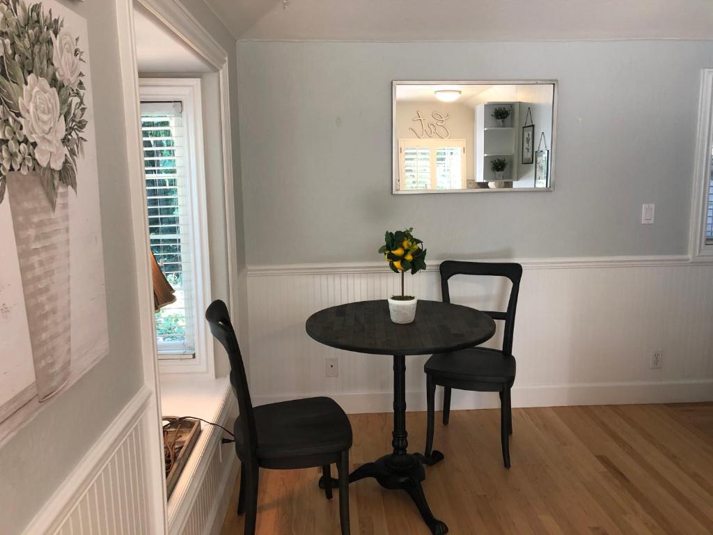 una sala da pranzo con tavolo, 2 sedie e uno specchio di Hacienda Cottage a Walnut Creek