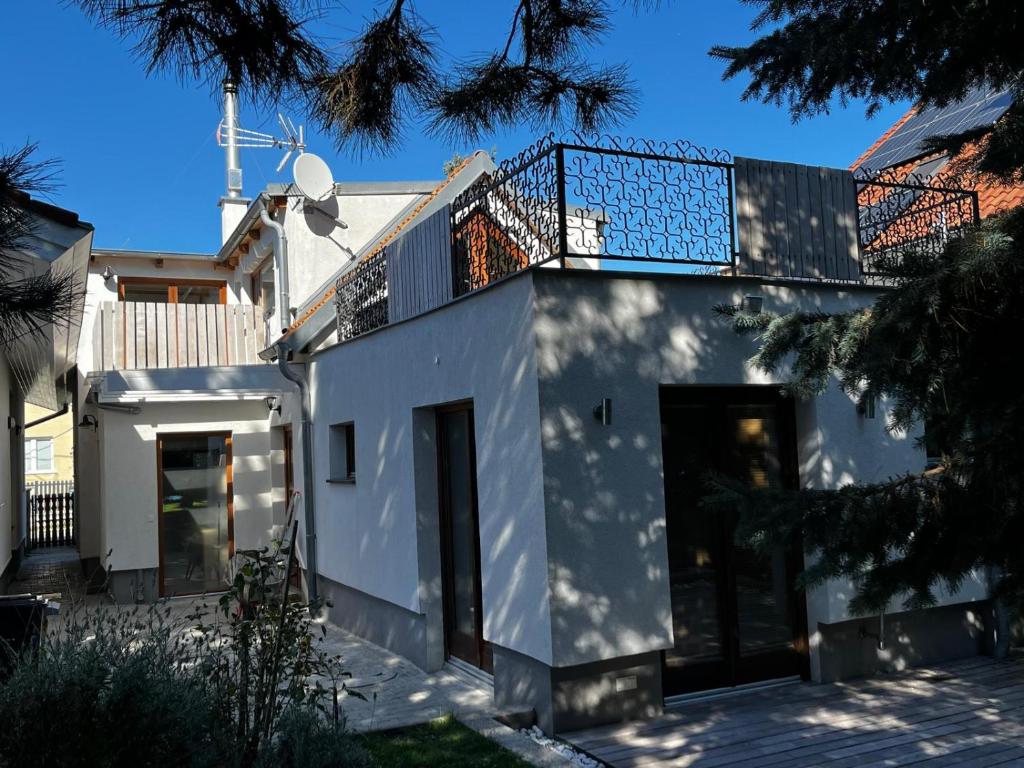 a white house with a balcony on top of it at Danube Gardens in Vienna