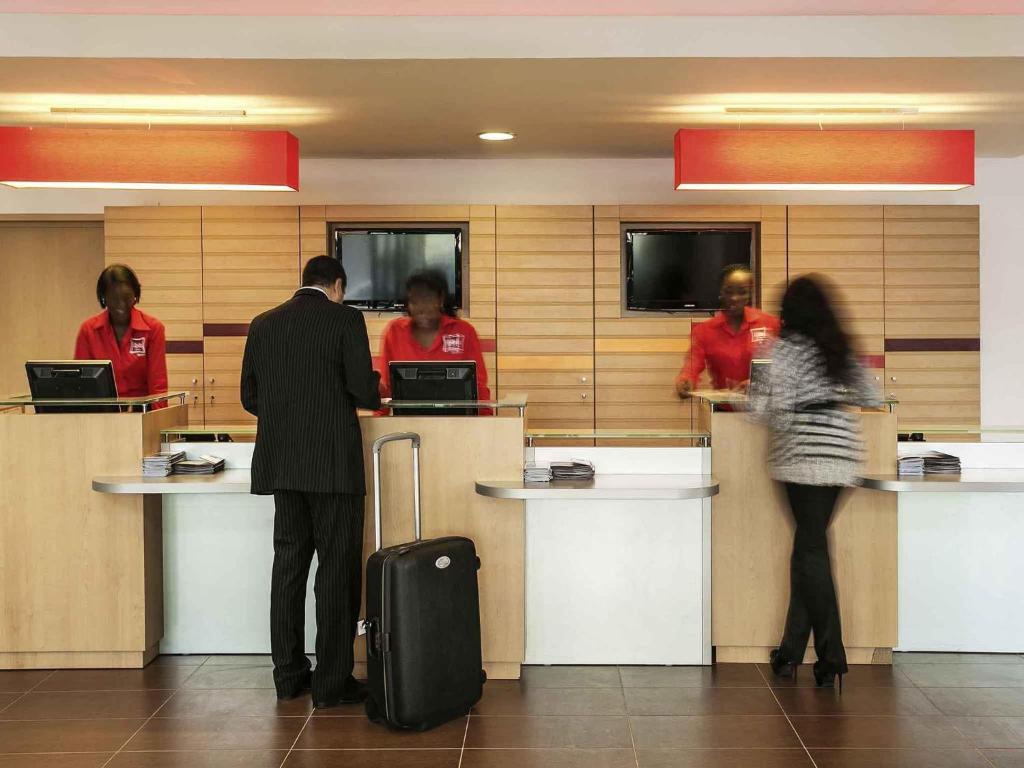 a group of people standing at a counter at Ibis Lagos Ikeja in Ikeja