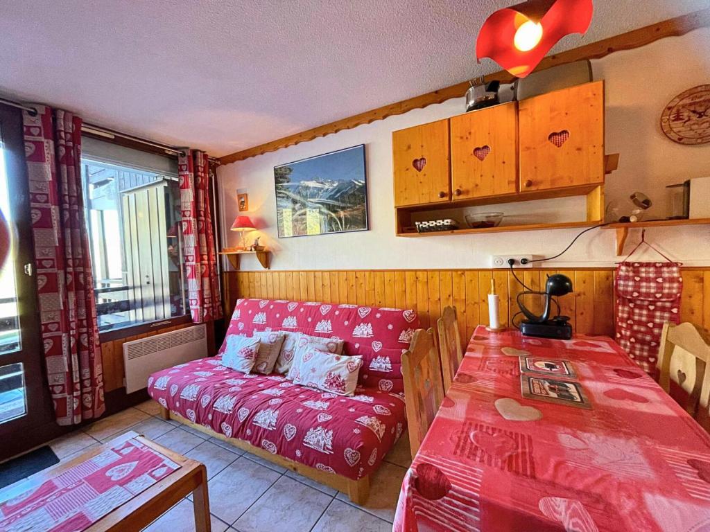 una sala de estar con un sofá y una mesa en Résidence Villaret - Grand studio 4 personnes aux pieds des pistes, vue montagne. MAE-8891, en Les Menuires