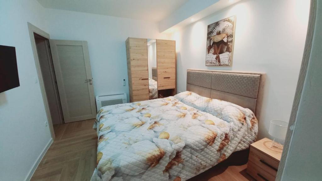 a bedroom with a bed with a comforter on it at La Terrazza in Tivat