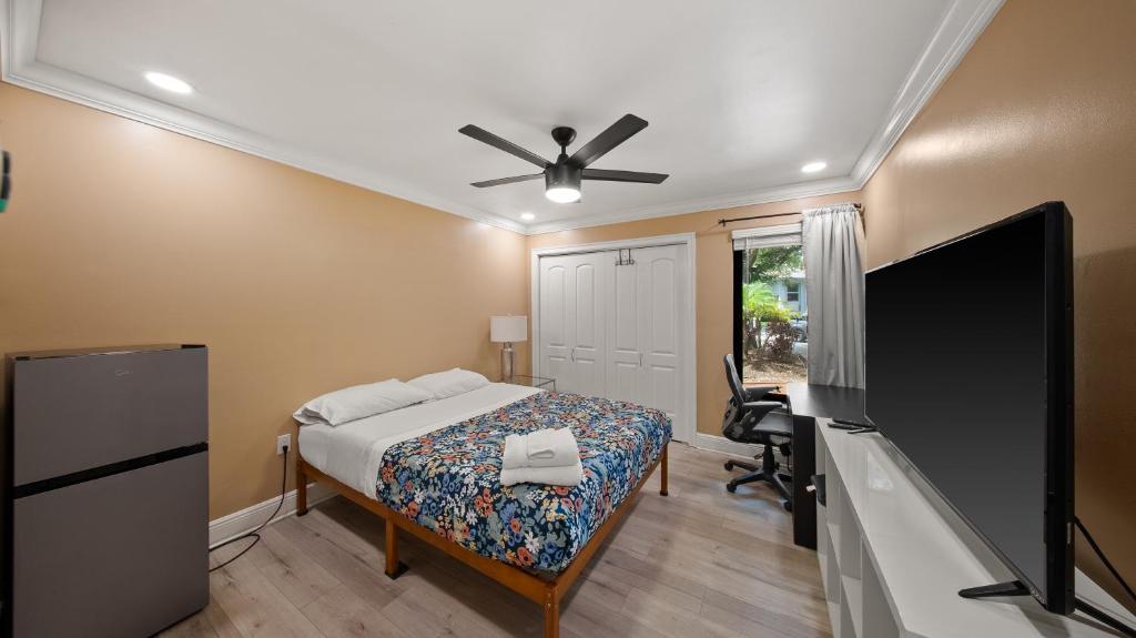 a bedroom with a bed and a flat screen tv at Luxury Queen Room, Walk to UM, Free Car Service! in Miami